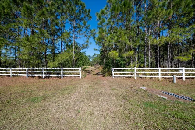 a view of a green field with wooden fence