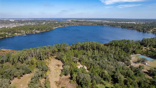 an aerial view of residential houses with outdoor space and ocean view