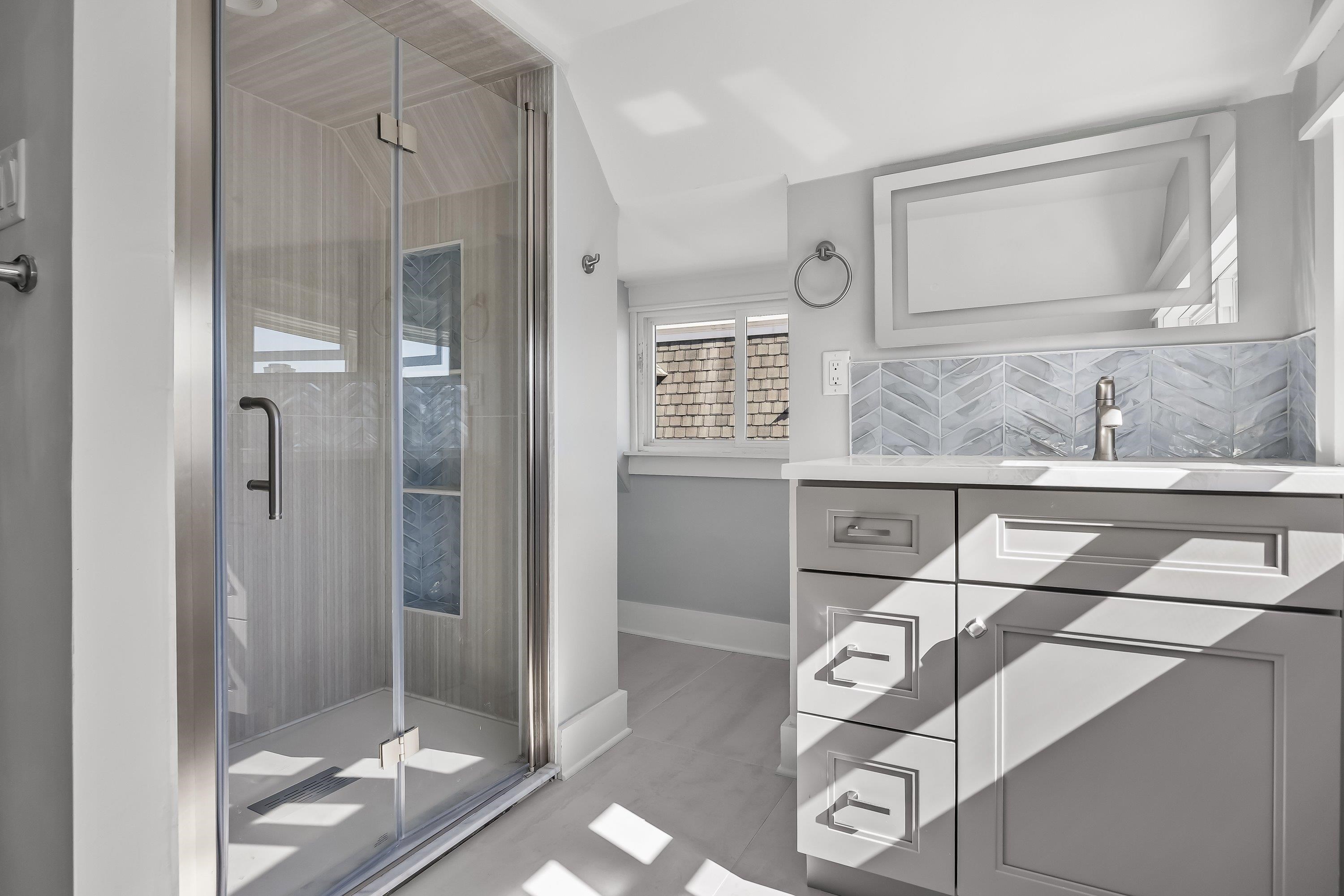 733 Wesley Road, Unit NORTH Ocean City, NJ 08226 - Photo 29 of 47 a bathroom with a granite countertop sink a mirror and shower