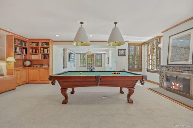 a living room with furniture pool table and chairs