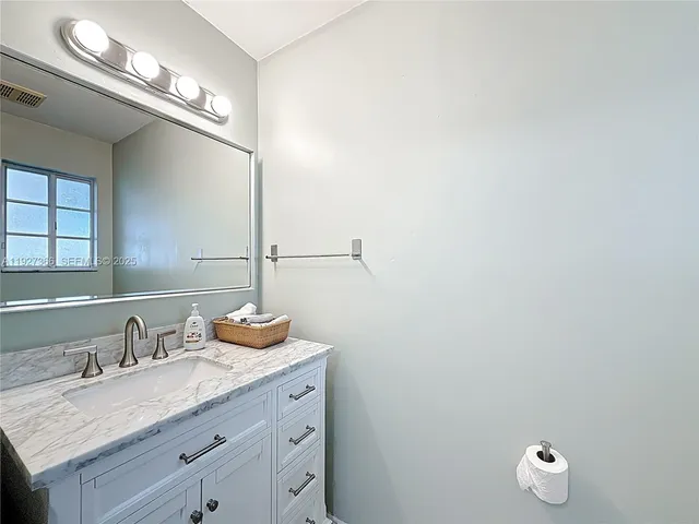 a bathroom with a granite countertop sink and a mirror