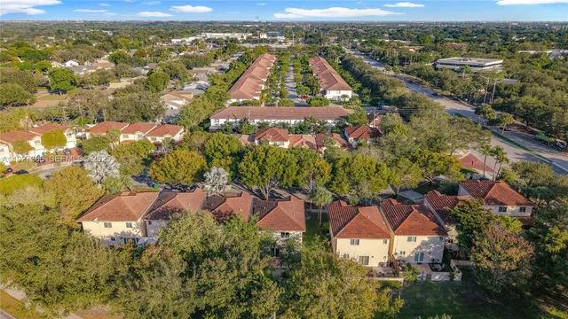 an aerial view of residential houses with outdoor space and trees
