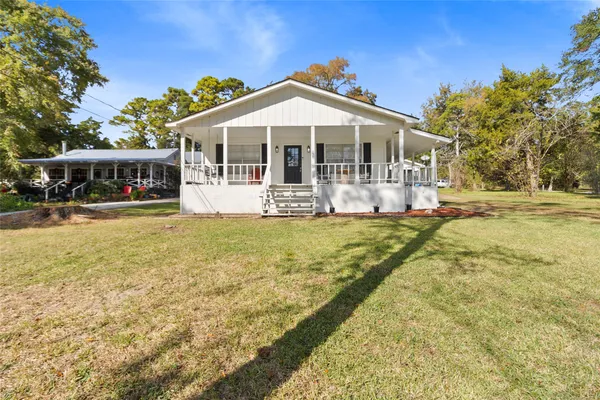 a front view of a house with swimming pool and porch with furniture