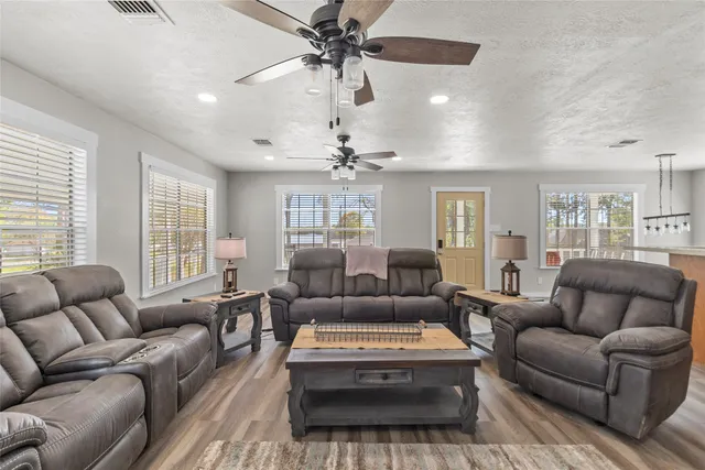 a living room with furniture ceiling fan and a window