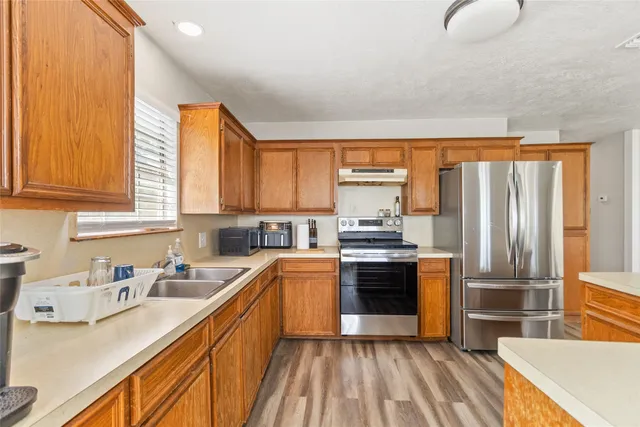 a kitchen with stainless steel appliances granite countertop a sink stove and refrigerator
