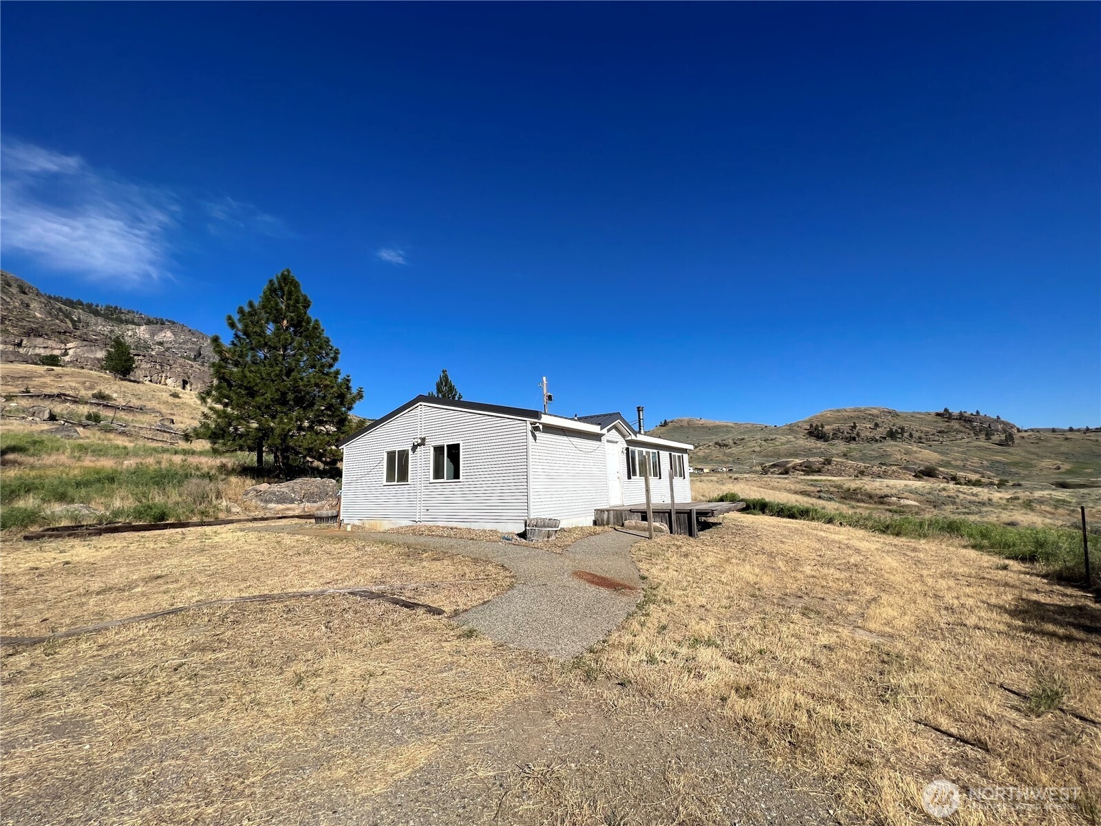 105 Swanson Mill Road Oroville, WA 98844 - Photo 6 of 37 a view of a large white house with a yard