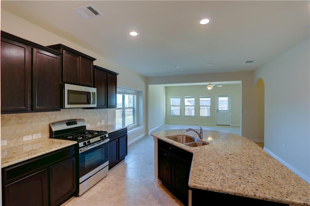 a kitchen with stainless steel appliances granite countertop a stove and a sink