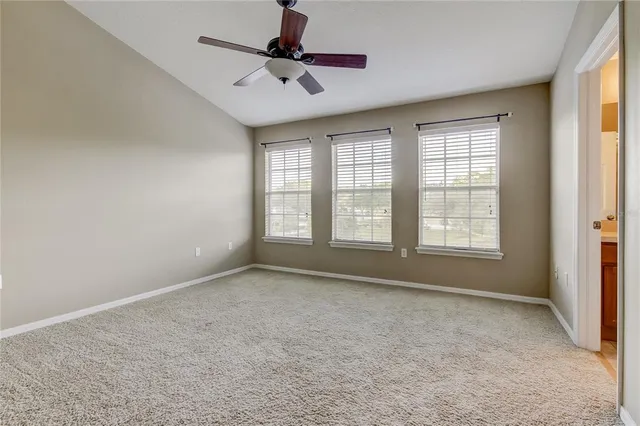 a view of an empty room and a ceiling fan