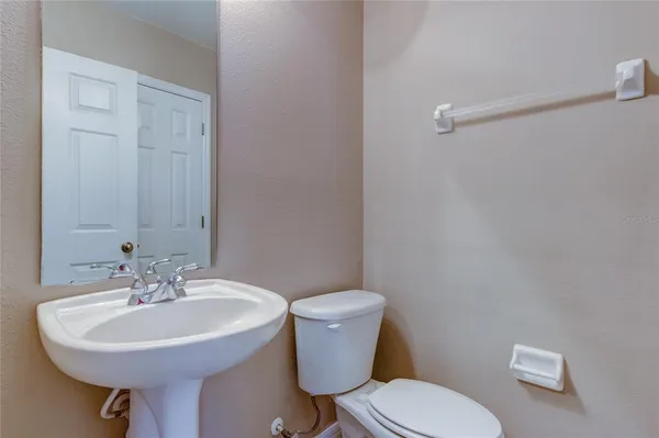 a bathroom with a sink a toilet and a mirror