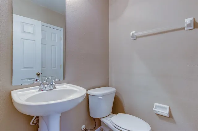 a bathroom with a sink a toilet and a mirror