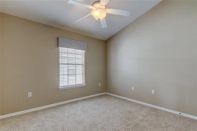 an empty room with a chandelier fan