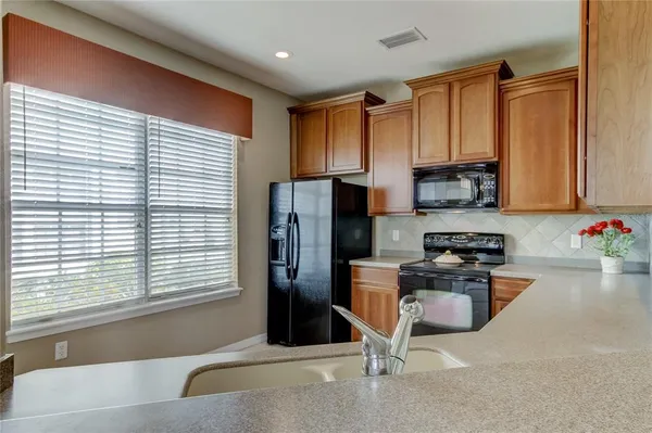 a kitchen with stainless steel appliances granite countertop a refrigerator and a sink