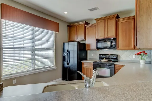 a kitchen with stainless steel appliances granite countertop a refrigerator and a sink