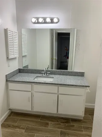 a bathroom with a granite countertop sink and a mirror