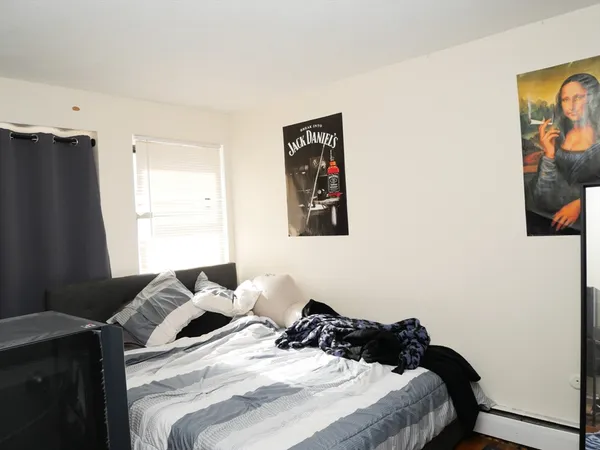 a bedroom with a bed and a painting on the wall