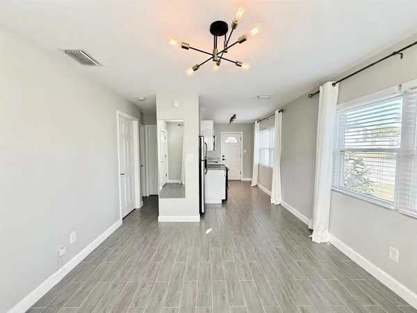 a view of a livingroom with wooden floor and a ceiling fan