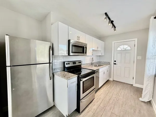 a kitchen with a refrigerator a stove top oven a sink and dishwasher
