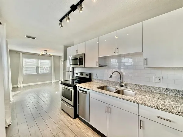a kitchen with stainless steel appliances granite countertop a sink a stove and cabinets