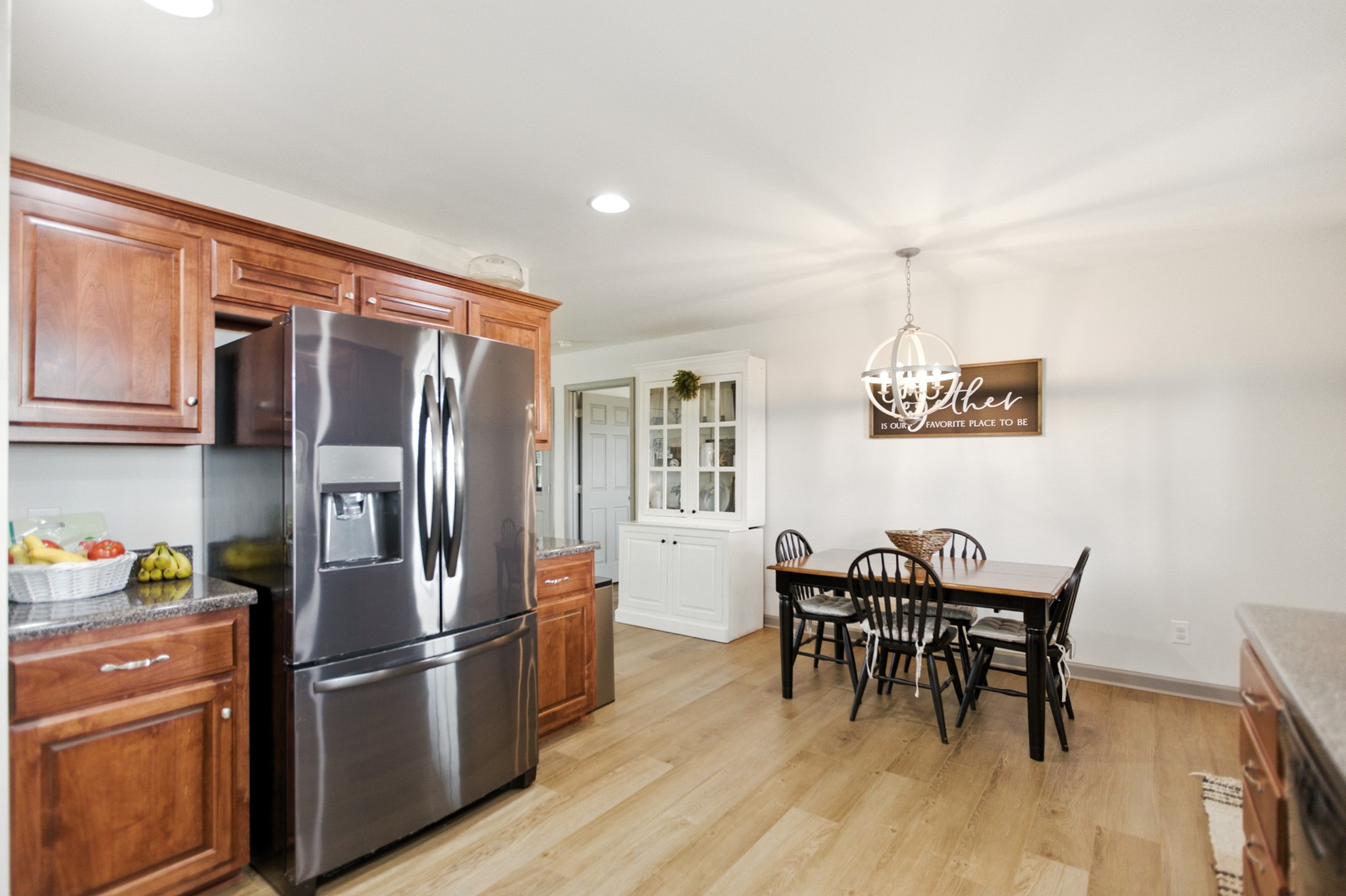 6411 Spring Creek Road Tullahoma, TN 37388 - Photo 18 of 57 a kitchen with stainless steel appliances a refrigerator a stove a dining table and chairs with wooden floor
