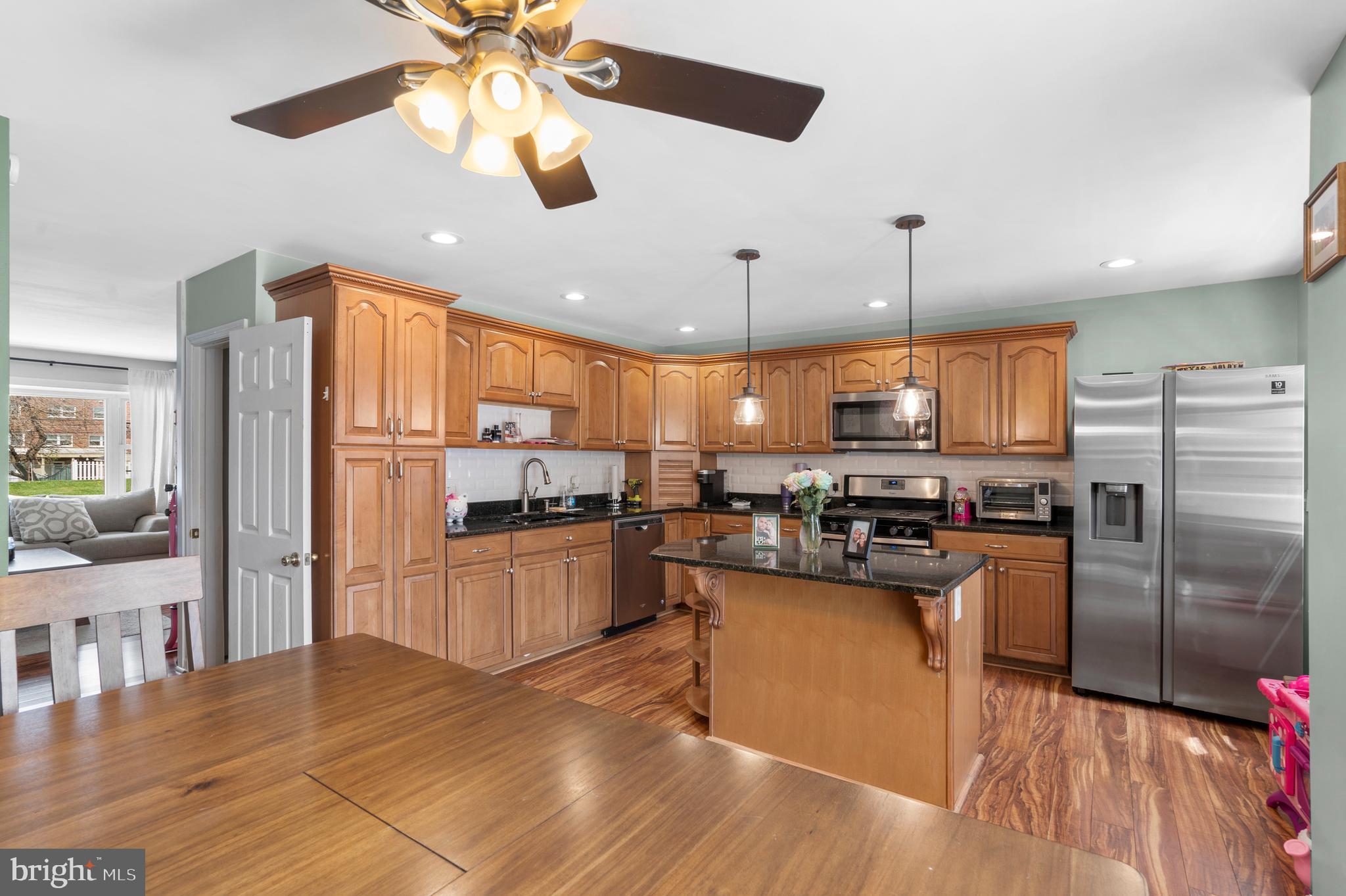 12413 Dunks Ferry Road Philadelphia, PA 19154 - Photo 12 of 35 a kitchen with stainless steel appliances kitchen island granite countertop a refrigerator a stove and a wooden floors