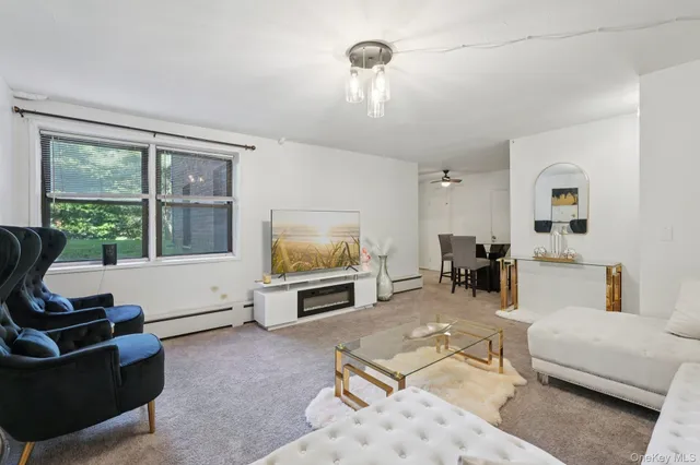 a living room with furniture a large window and a flat screen tv