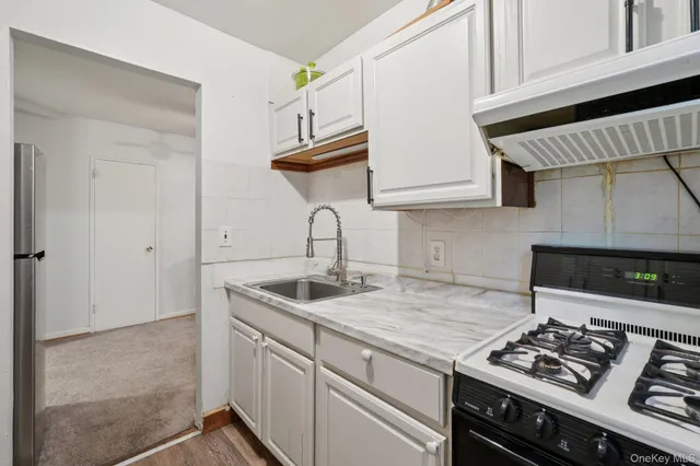 a kitchen with stainless steel appliances granite countertop a sink stove and cabinets