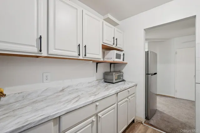 a kitchen with granite countertop white cabinets and stainless steel appliances