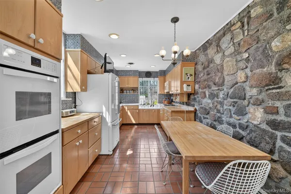 a kitchen with stainless steel appliances kitchen island granite countertop a sink stove and refrigerator