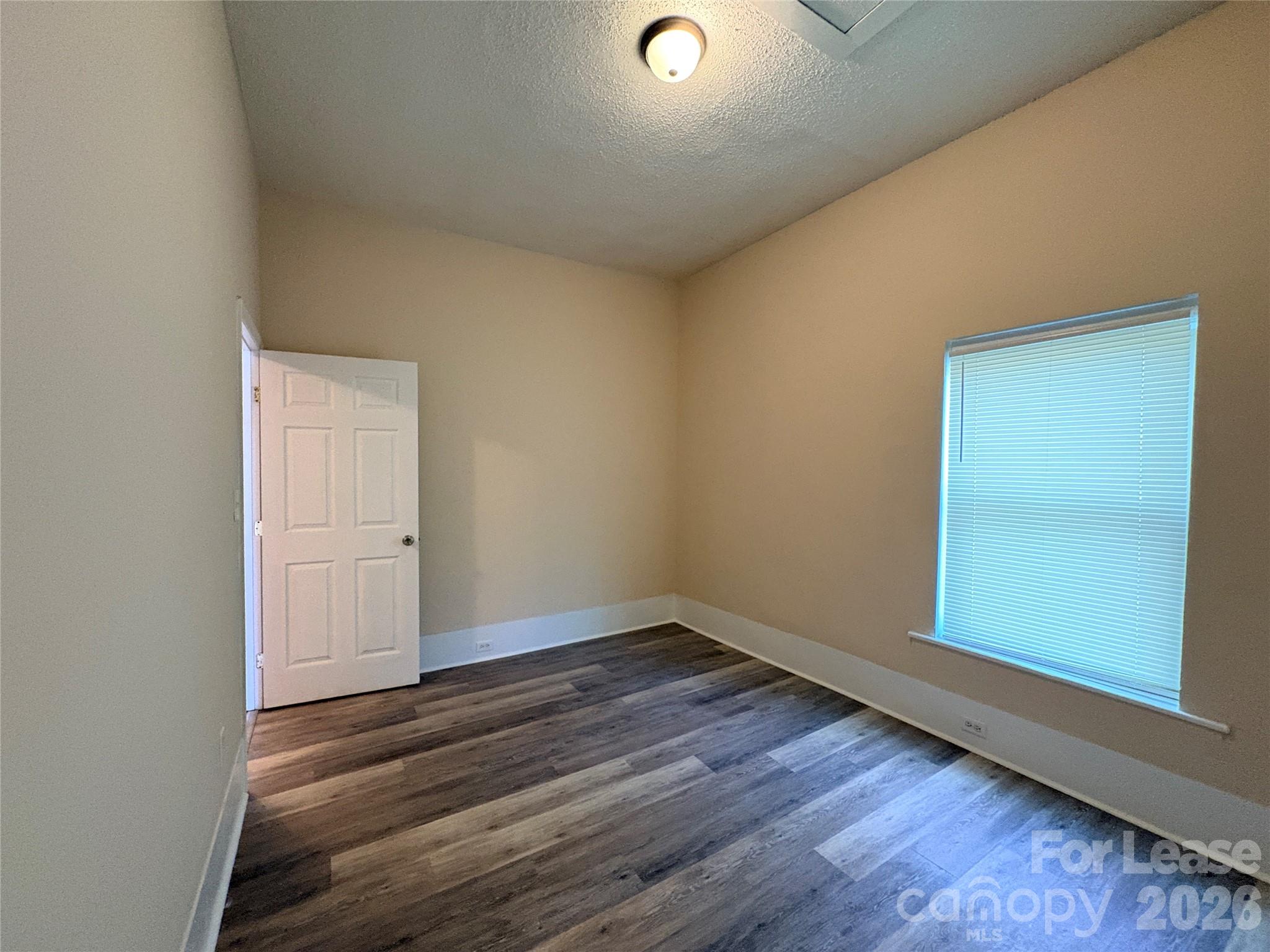 1109 6th Street, Unit B Lancaster, SC 29720 - Photo 14 of 22 an empty room with wooden floor and windows