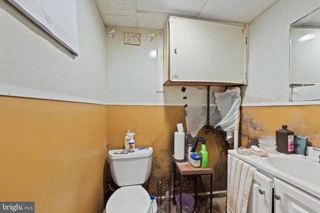 a bathroom with a toilet sink and mirror