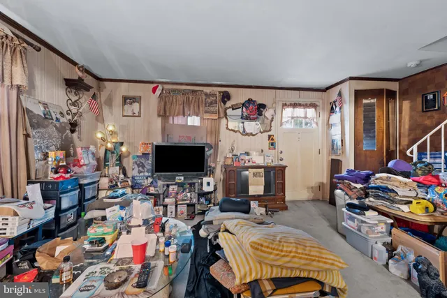 a bed room with furniture a flat screen tv and a window