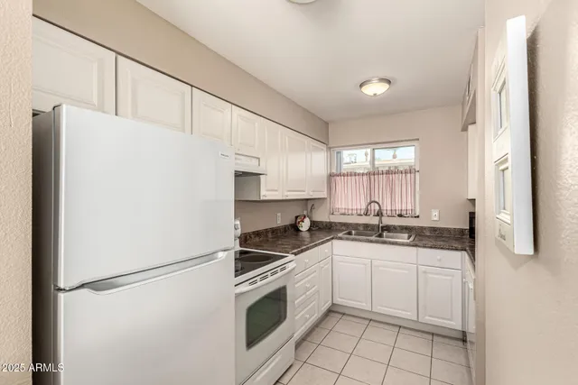 a kitchen with white cabinets and white appliances