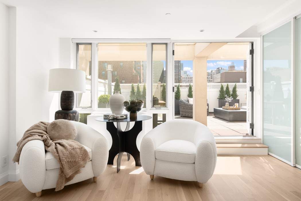 435 East 76th Street, Unit PHB Manhattan, NY 10021 - Photo 1 of 28 a living room with furniture and a large window