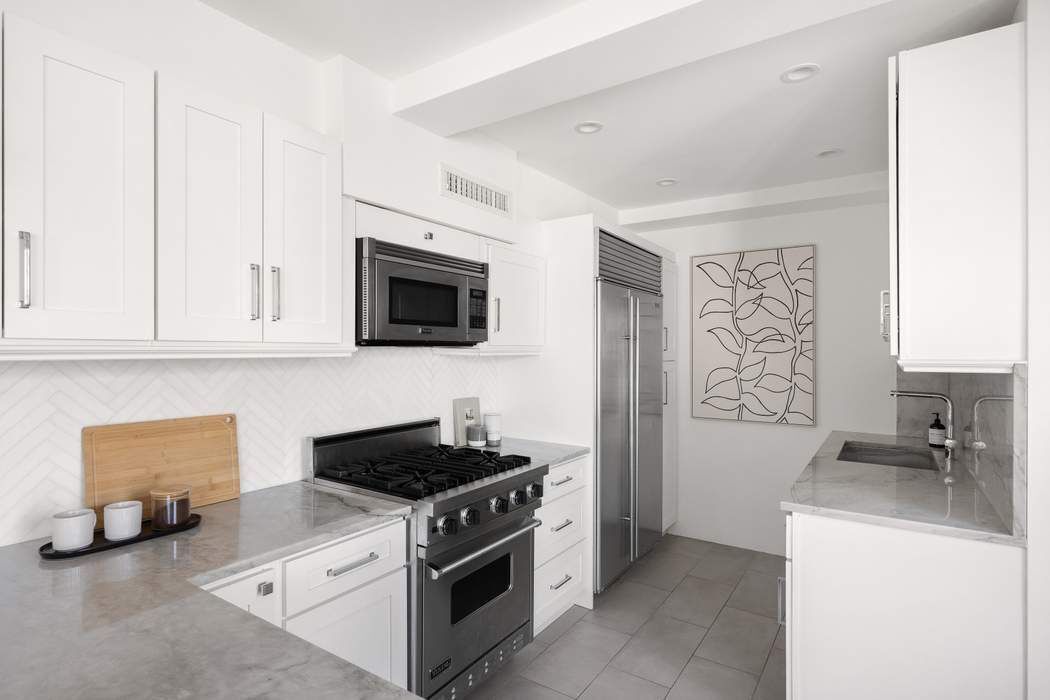 435 East 76th Street, Unit PHB Manhattan, NY 10021 - Photo 18 of 28 a kitchen with stainless steel appliances a stove a microwave and a refrigerator