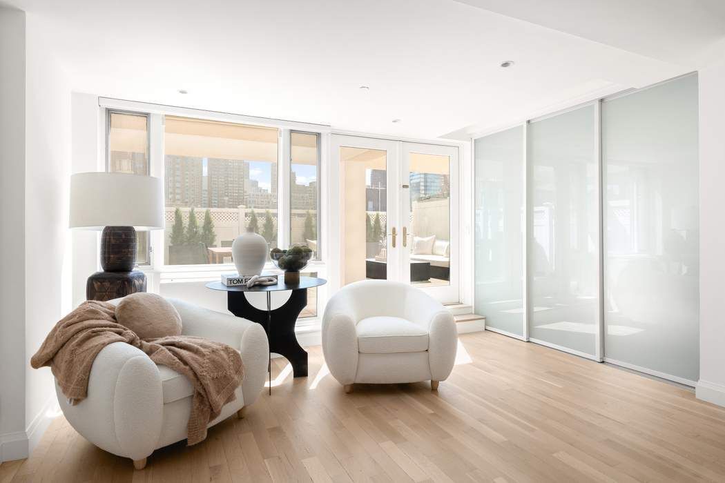 435 East 76th Street, Unit PHB Manhattan, NY 10021 - Photo 9 of 28 a living room with furniture and a large window