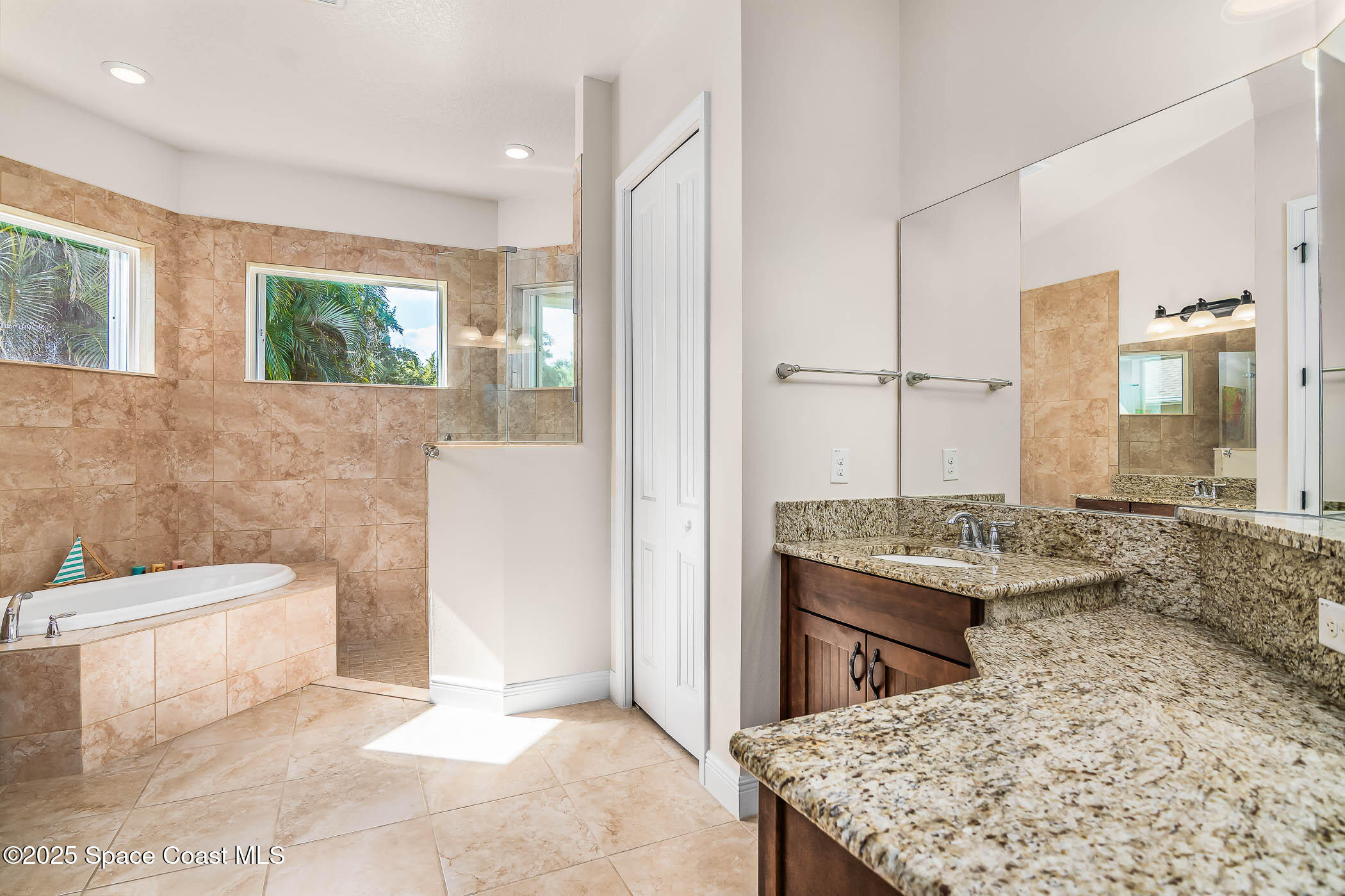 1953 Rockledge Drive Rockledge, FL 32955 - Photo 24 of 83 a bathroom with a granite countertop sink a toilet a mirror and bathtub