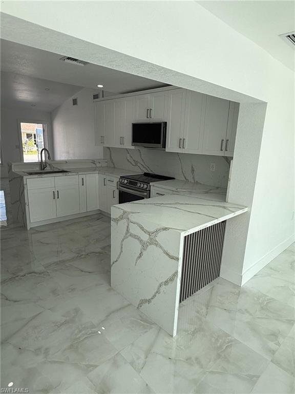 2823 Janet Street Matlacha, FL 33993 - Photo 4 of 16 a kitchen that has a sink and a stove in it