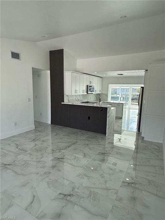 2823 Janet Street Matlacha, FL 33993 - Photo 6 of 16 a view of kitchen with kitchen island granite countertop a refrigerator and cabinets