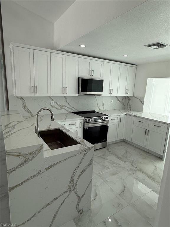 2823 Janet Street Matlacha, FL 33993 - Photo 8 of 16 a kitchen with a sink a stove and cabinets