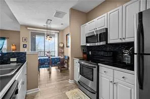 a kitchen with stainless steel appliances a stove a sink a microwave a dining table and chairs