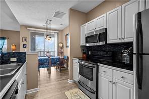 409 Stockton Ridge Cranberry Township, PA 16066 - Photo 6 of 19 a kitchen with stainless steel appliances a stove a sink a microwave a dining table and chairs