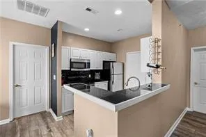 a kitchen with granite countertop a sink and refrigerator