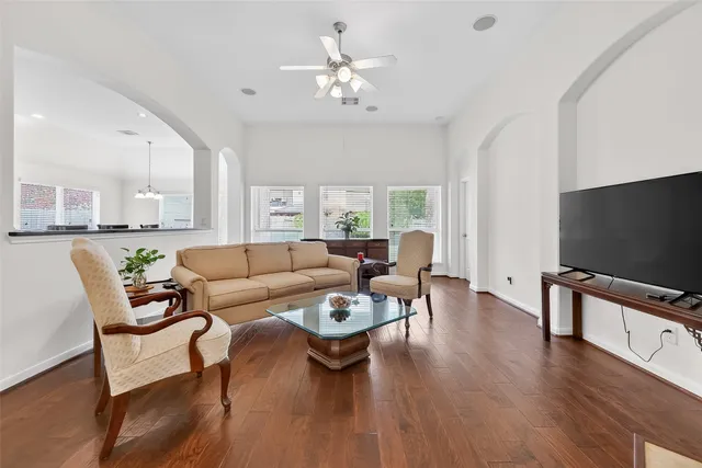 a living room with furniture flat screen tv and wooden floor