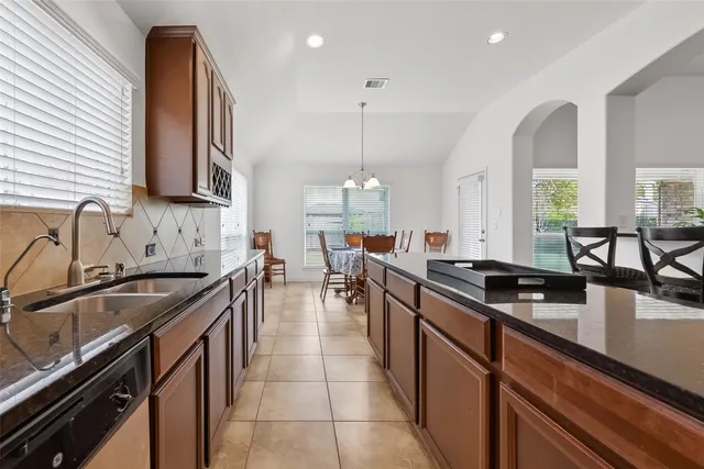 a kitchen with stainless steel appliances granite countertop a sink stove and cabinets