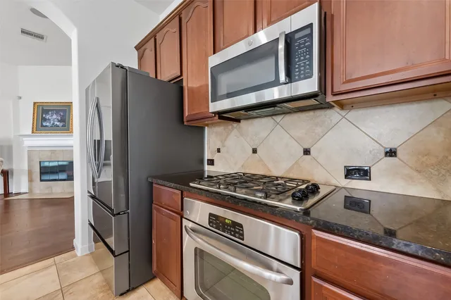 a kitchen with stainless steel appliances granite countertop a stove microwave and refrigerator