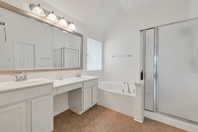a bathroom with a double vanity sink mirror and bathtub