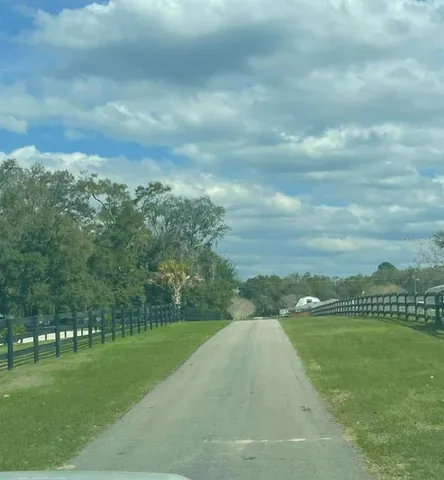 a front view of a house with a garden and trees