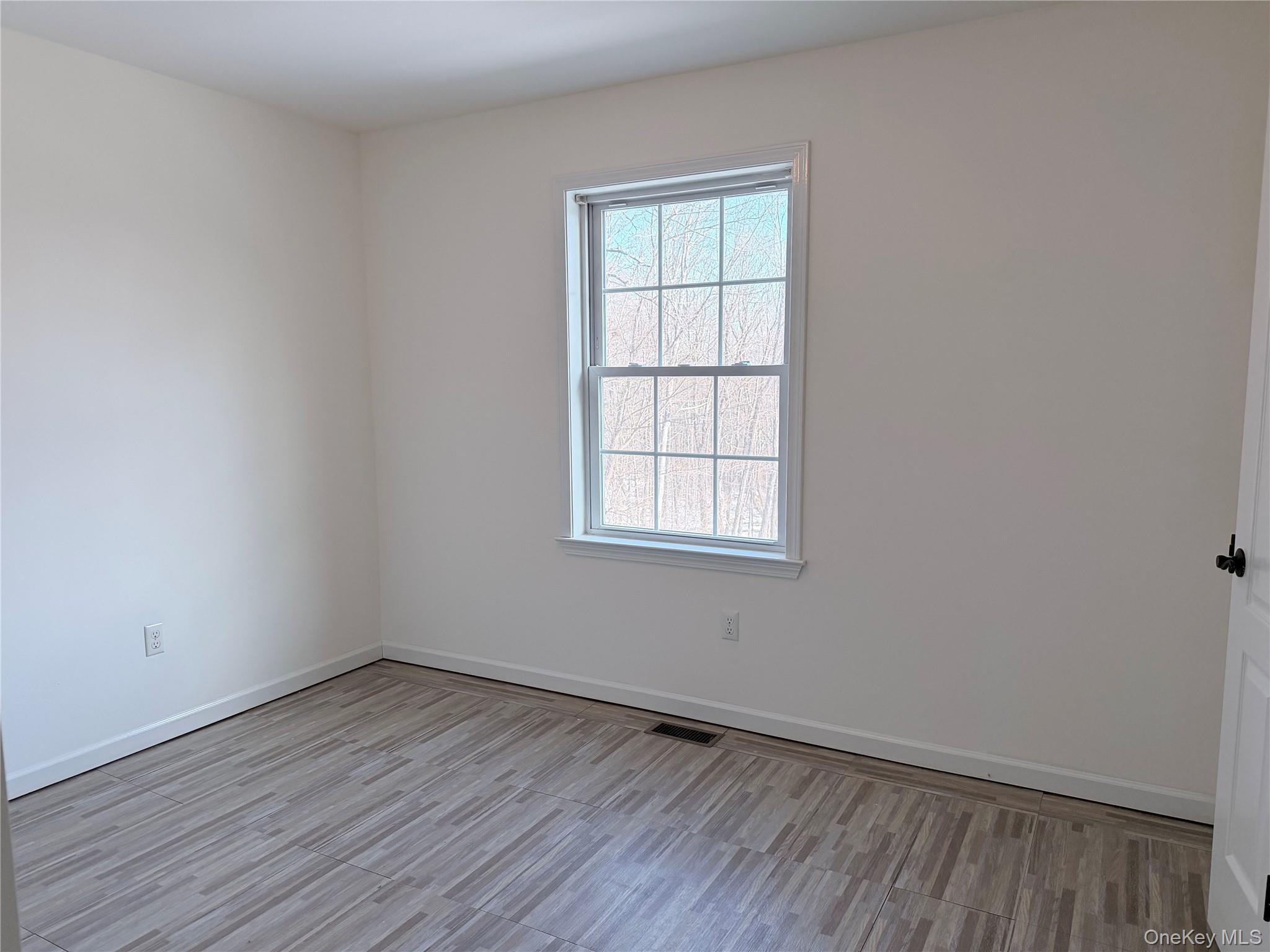 750 Mullock Road Port Jervis, NY 12771 - Photo 18 of 41 an empty room with wooden floor and windows