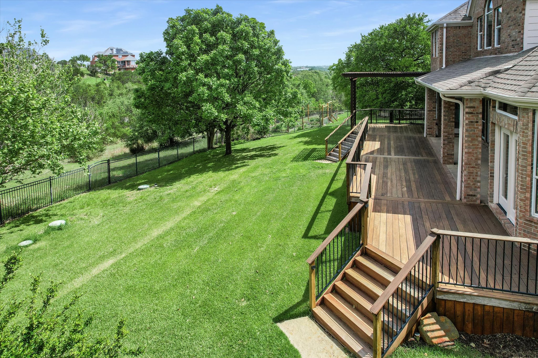 1400 Tom Sawyer Road Austin, TX 78737 - Photo 33 of 40 Expansive multi-level wood-finish deck with integrated stairs and black metal railings