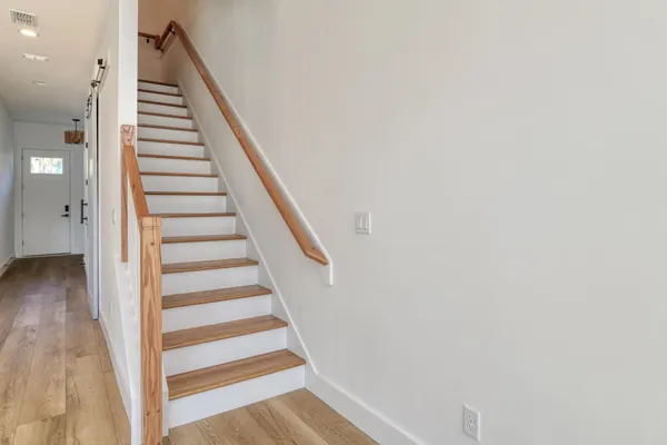 a view of a hallway with wooden floor and entryway